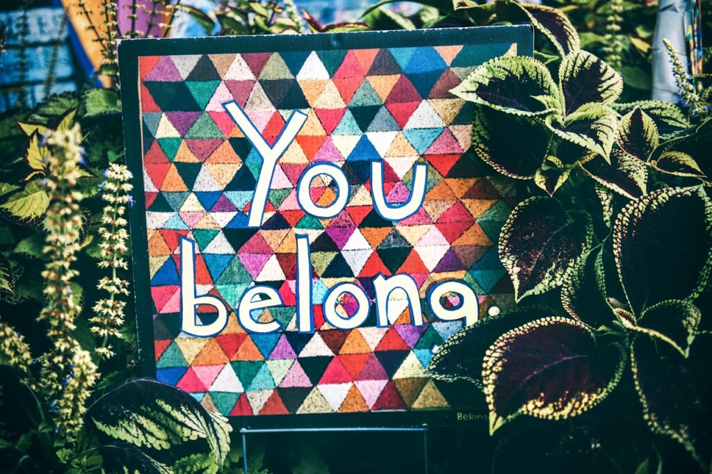 A patchwork quilt sign with the text "You belong"